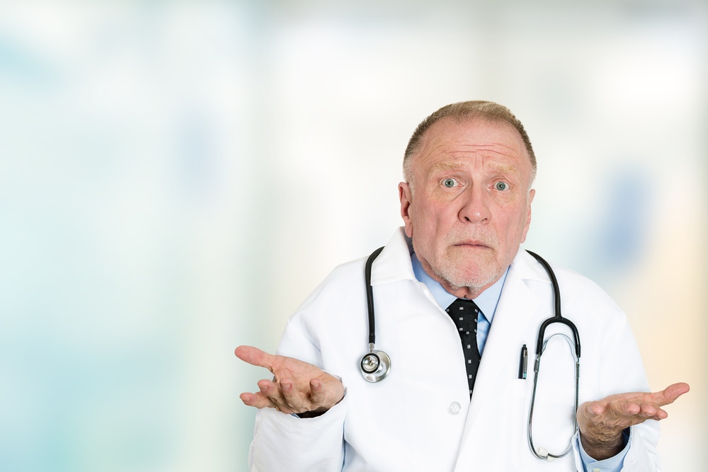 Closeup portrait clueless senior health care professional doctor with stethoscope, has no answer, doesn't know right diagnosis standing in hospital hallway isolated clinic office windows background..jpeg